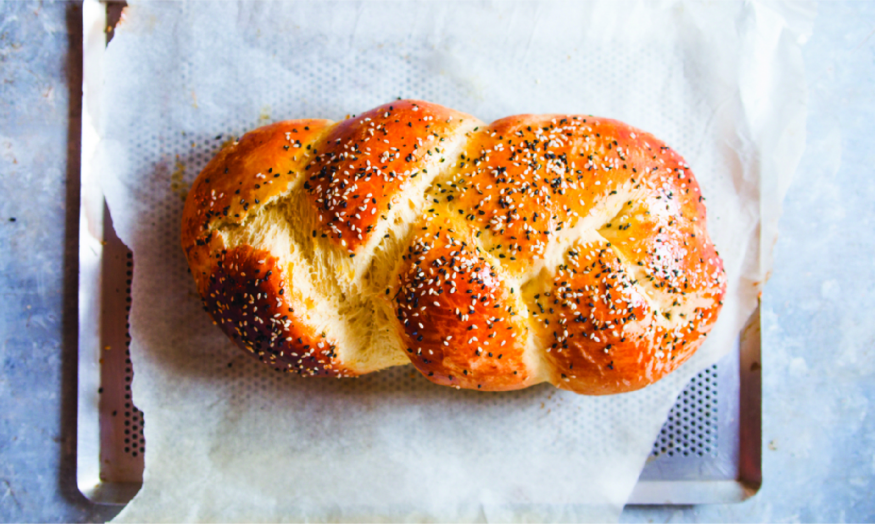 A loaf of challah bread on a cookie sheet.