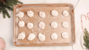 Blobs of divinity candy spaced out evenly on a cookie sheet.