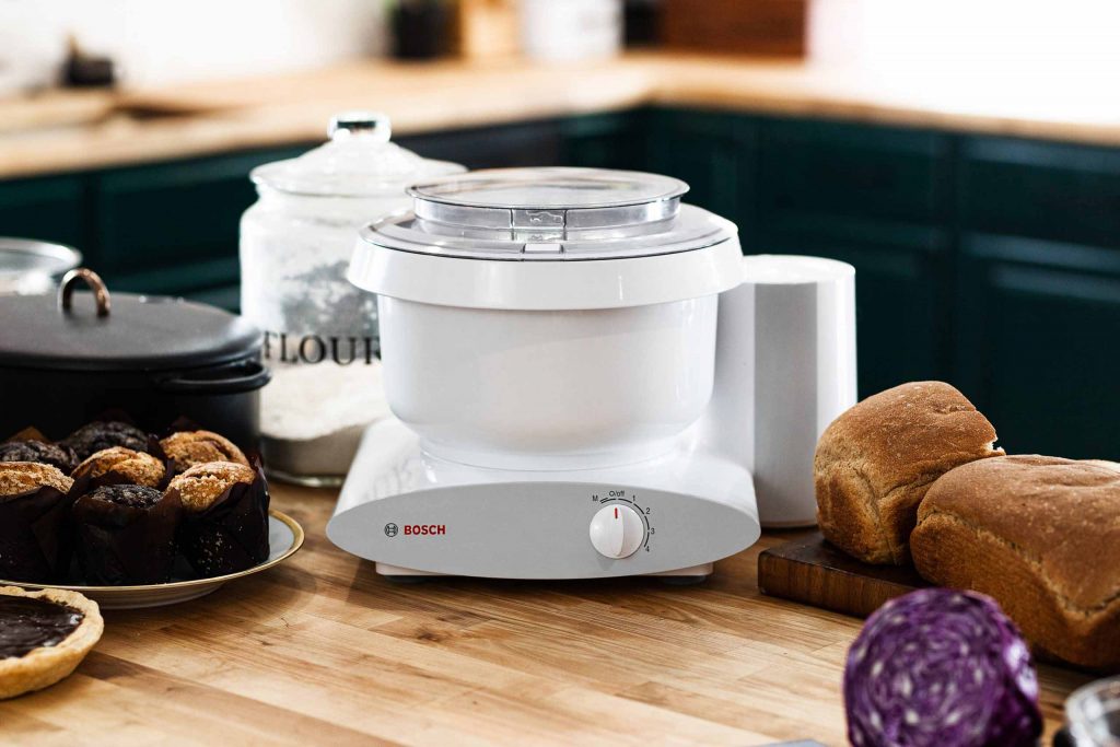 White Bosch Universal Plus Mixer on kitchen counter next to baked goods